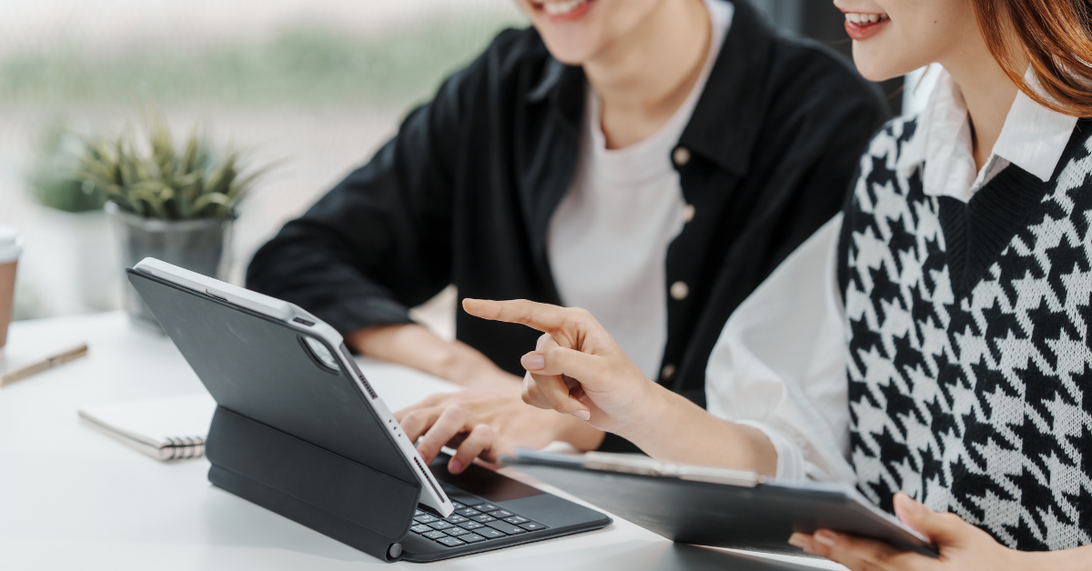 Dois estudantes conferindo informações de Atualidades no tablet sobre a mesa.