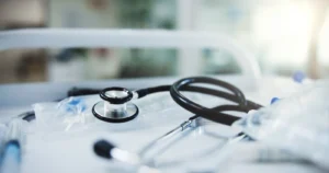 Concurso SES MG Hoje é o último dia para se inscrever! Estetoscópio médico sobre mesa branca, representando a carreira no Concurso SES MG.