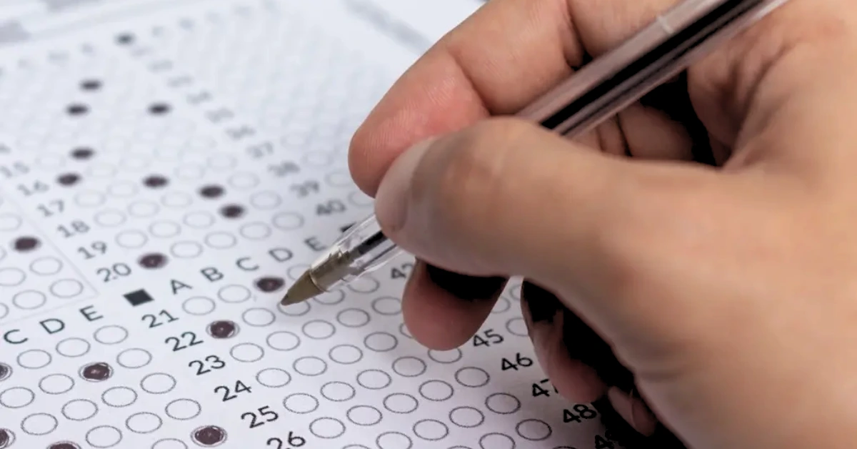 Pessoa preenchendo gabarito de concurso para ilustrar o dia da prova do Concurso SED SC.