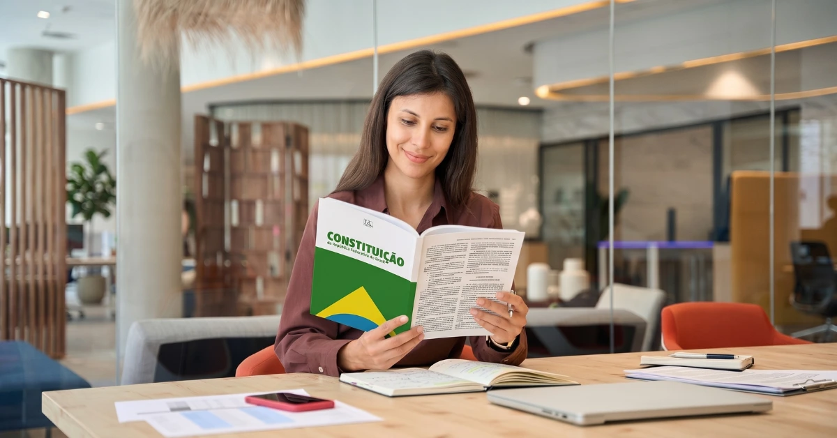 direito constitucional para concursos mulher lendo constituição em escritório para ilustrar direito constitucional para concursos
